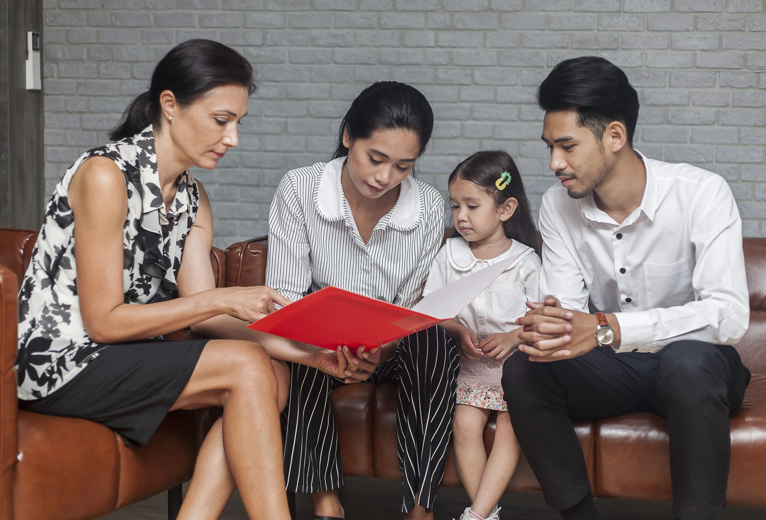 Asian Parent talking with teacher about Plan education for children. Young family and children discuss or advice with professional family psychologist in office